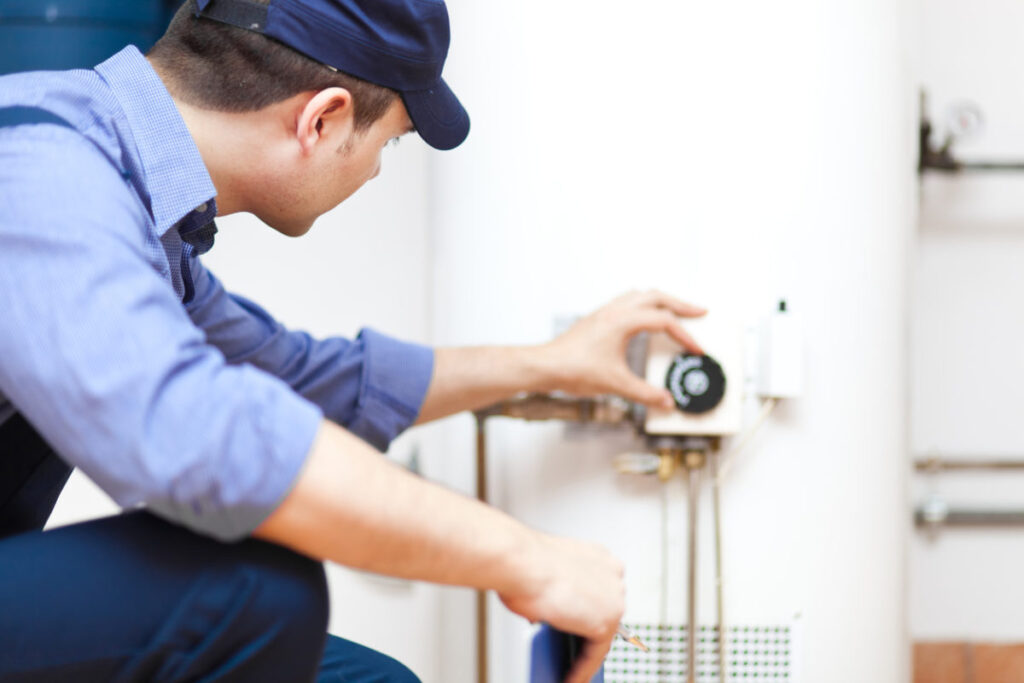 Plumber checking on a water heater after repairing it
